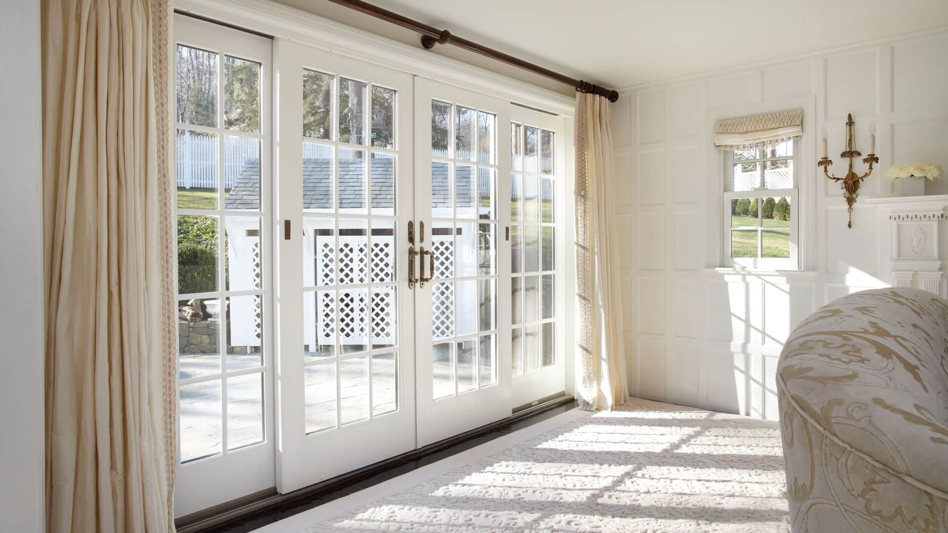 Living room with a pair of white-frame hinged patio doors leading to outdoor living area.