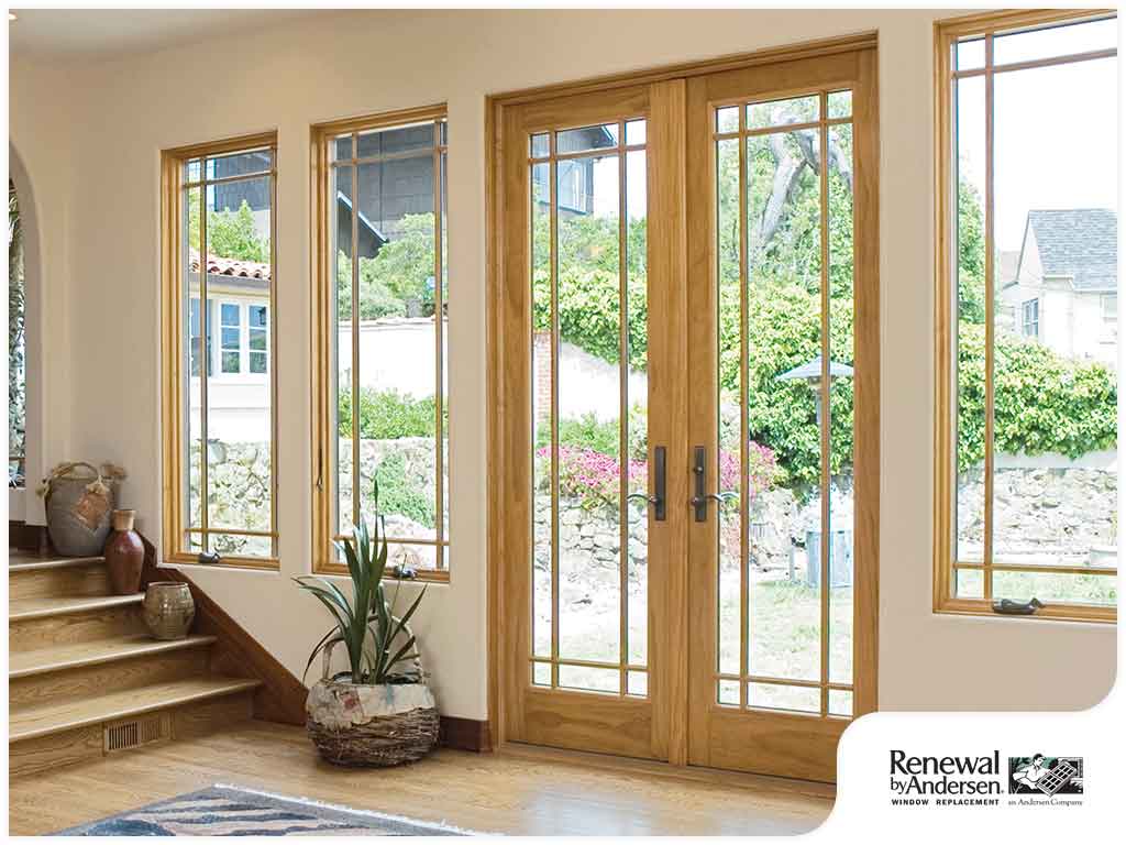 Interior of home with wood flooring, steps leading to second floor, and a pair of Frenchwood patio doors.