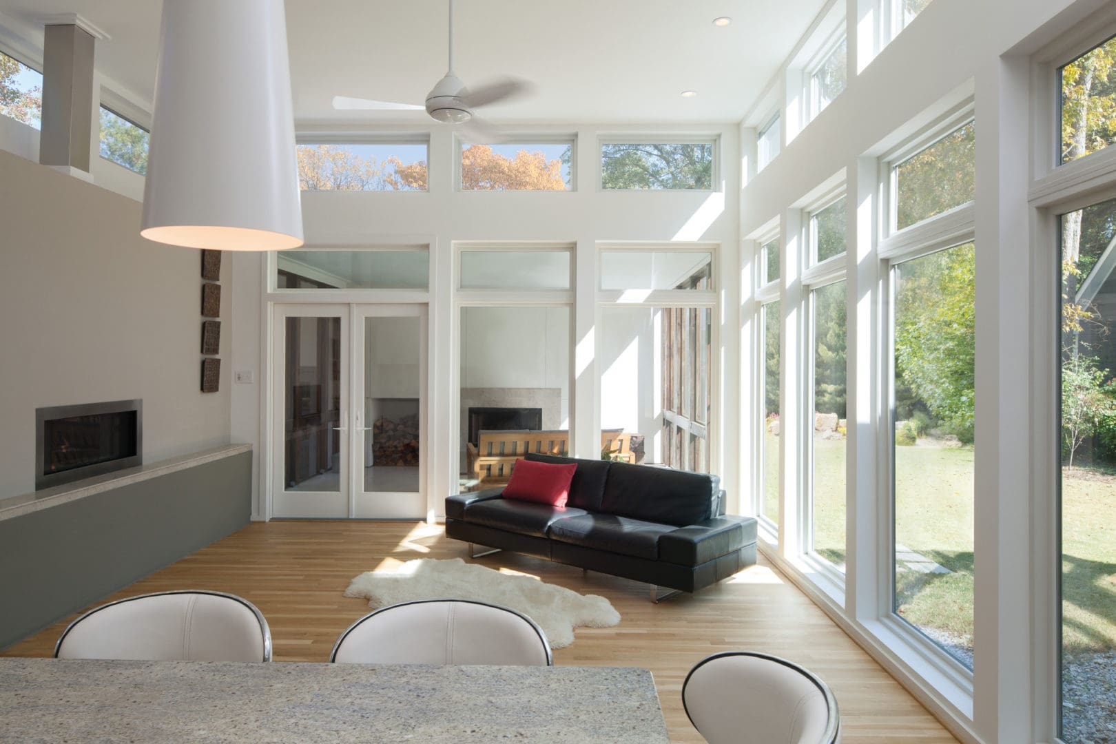 Energy-Efficient Windows Kenosha WI Living room with vaulted ceiling, wood flooring, and large energy-efficient windows overlooking scenic yard.
